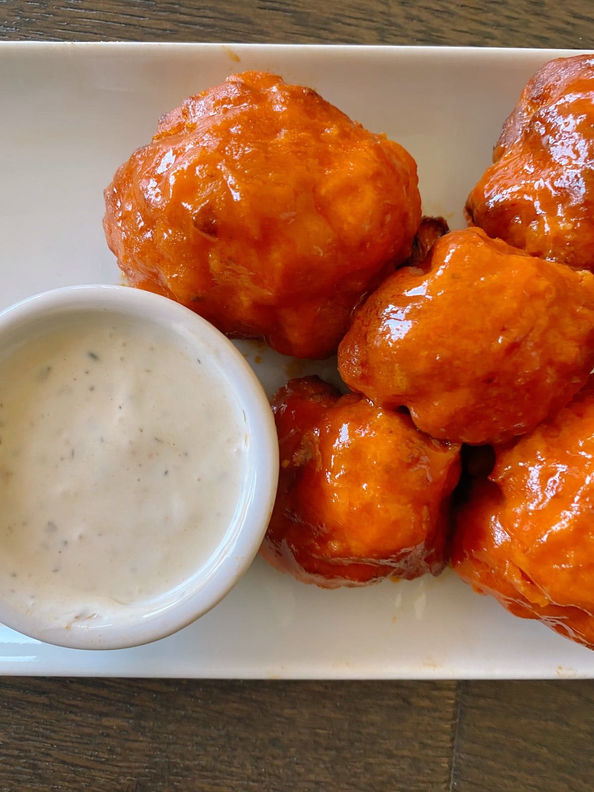 Delicious buffalo cauliflower wings with sauce on the side.