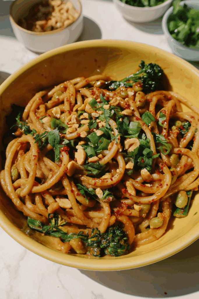 spicy peanut noodles with scallions and cilantro on top
