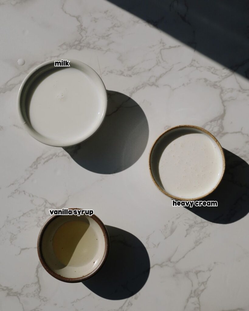 ingredients for the cold foam placed in small bowls on a kitchen countertop.