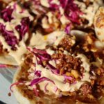 Shredded tofu tacos on a plate with cabbage.