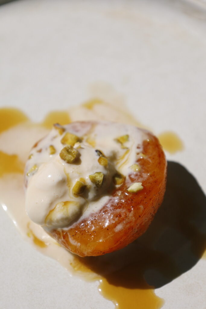 a close up of the cooked peaches with ice cream melting on top