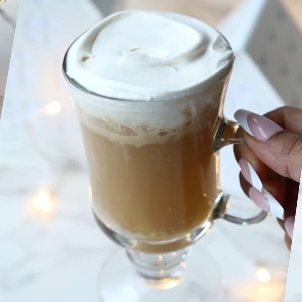 Harry potter butterbeer in a glass with whipped cream.