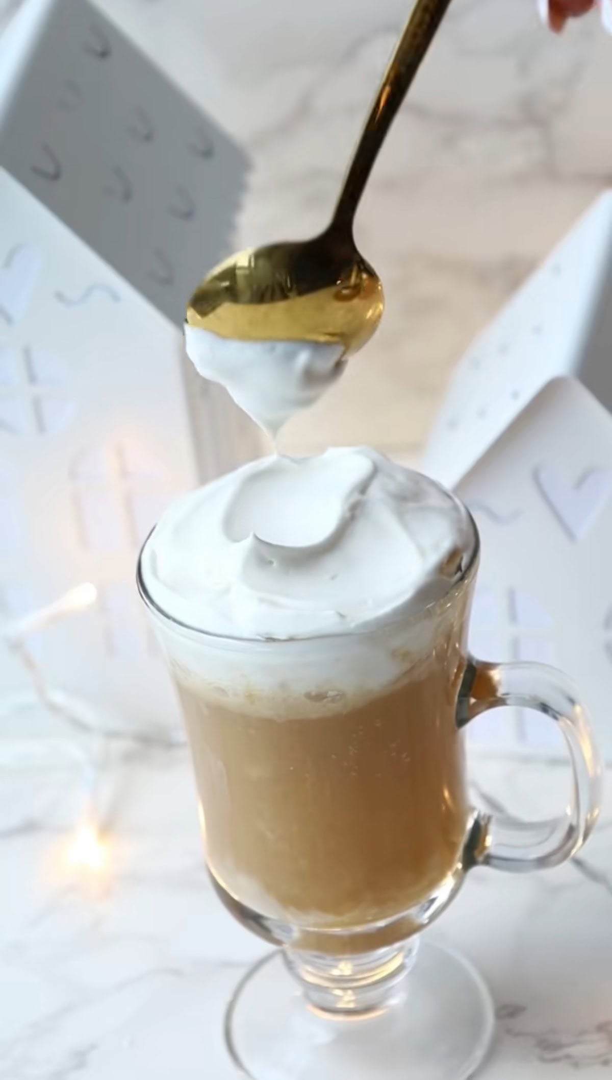 the harry potter butterbeer recipe in a tall drinking class with whipped cream on topo