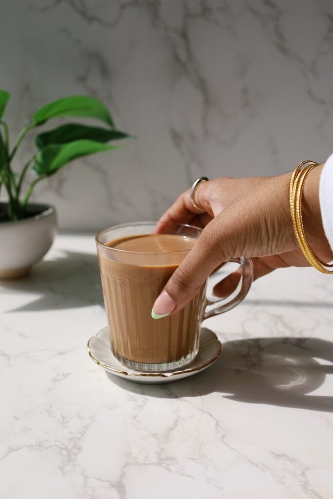 masala chai in a cup with a hand holding it