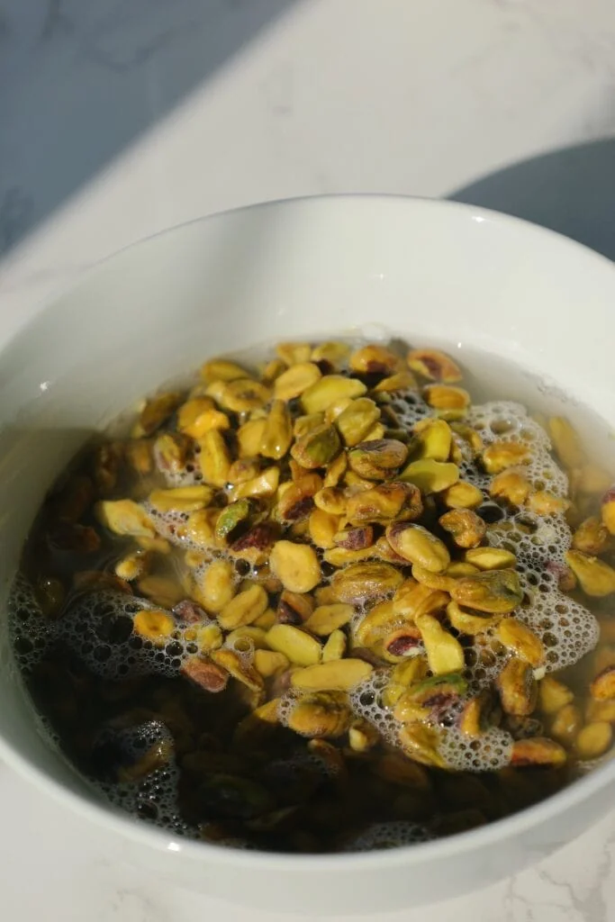 pistachios soaking in hot water in a bowl