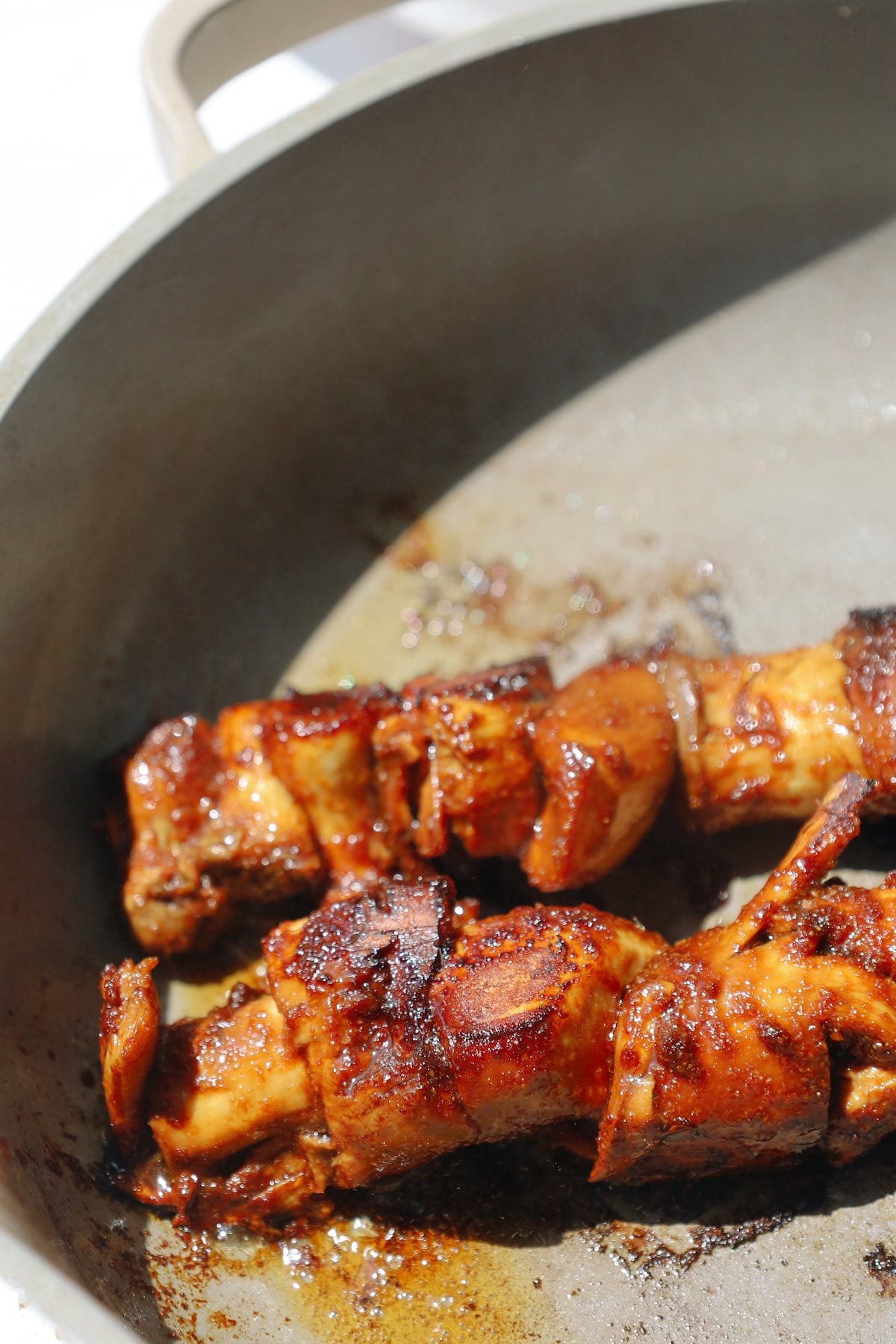 A skillet with seasoned oyster mushrooms being seared until golden brown.
