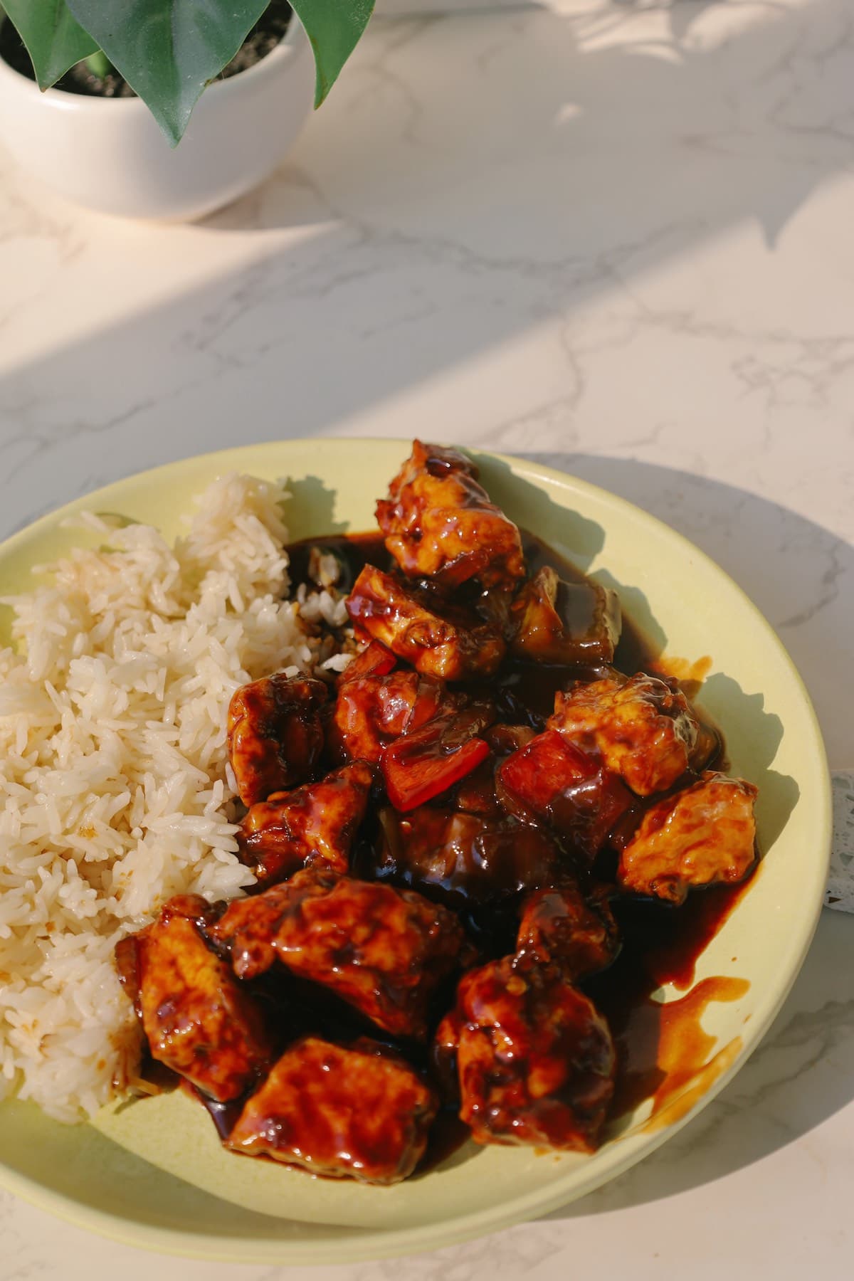 Sweet and sour tofu with rice on a plate.