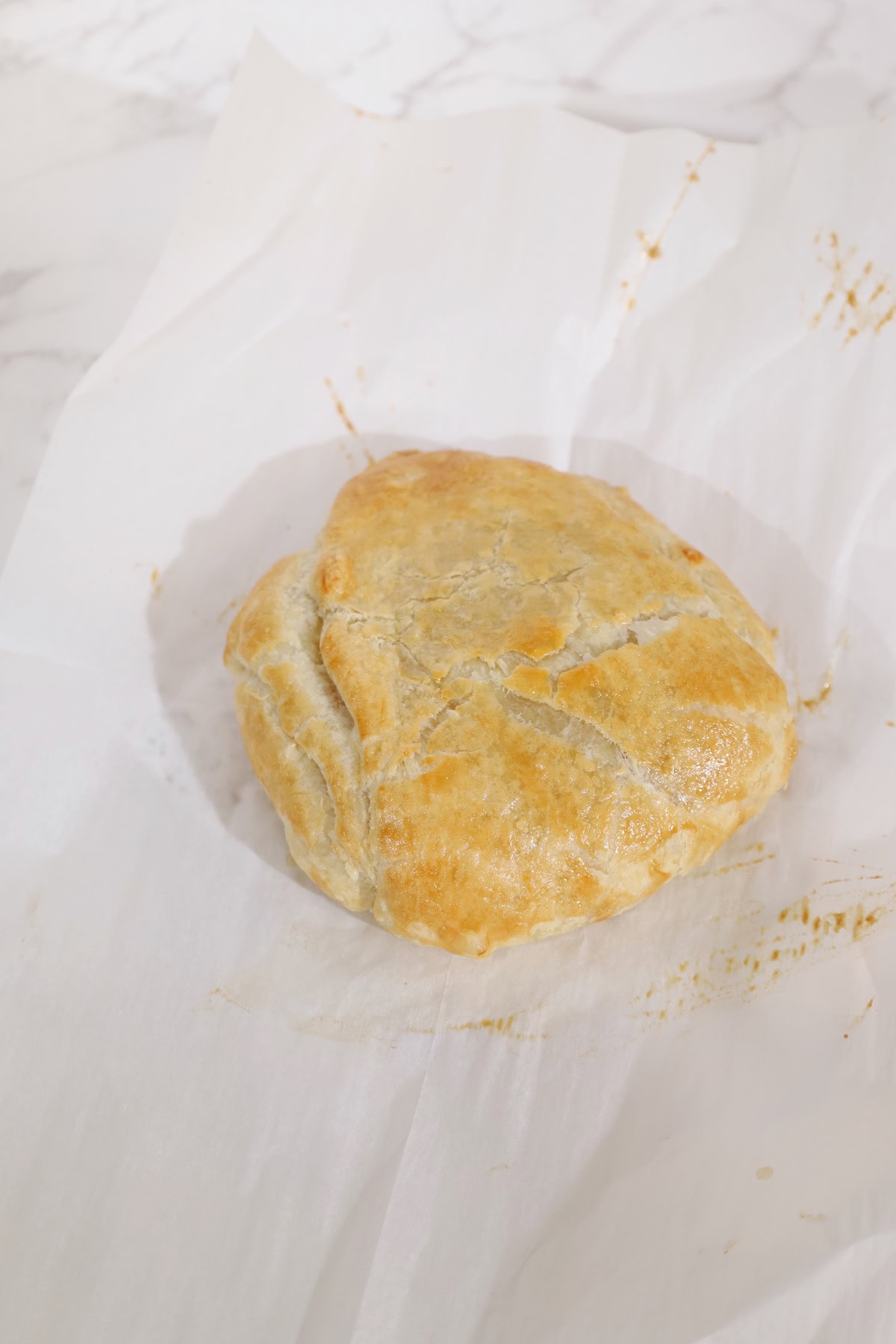 The baked brie parcel emerges from the oven with a puffed, golden-brown pastry crust.