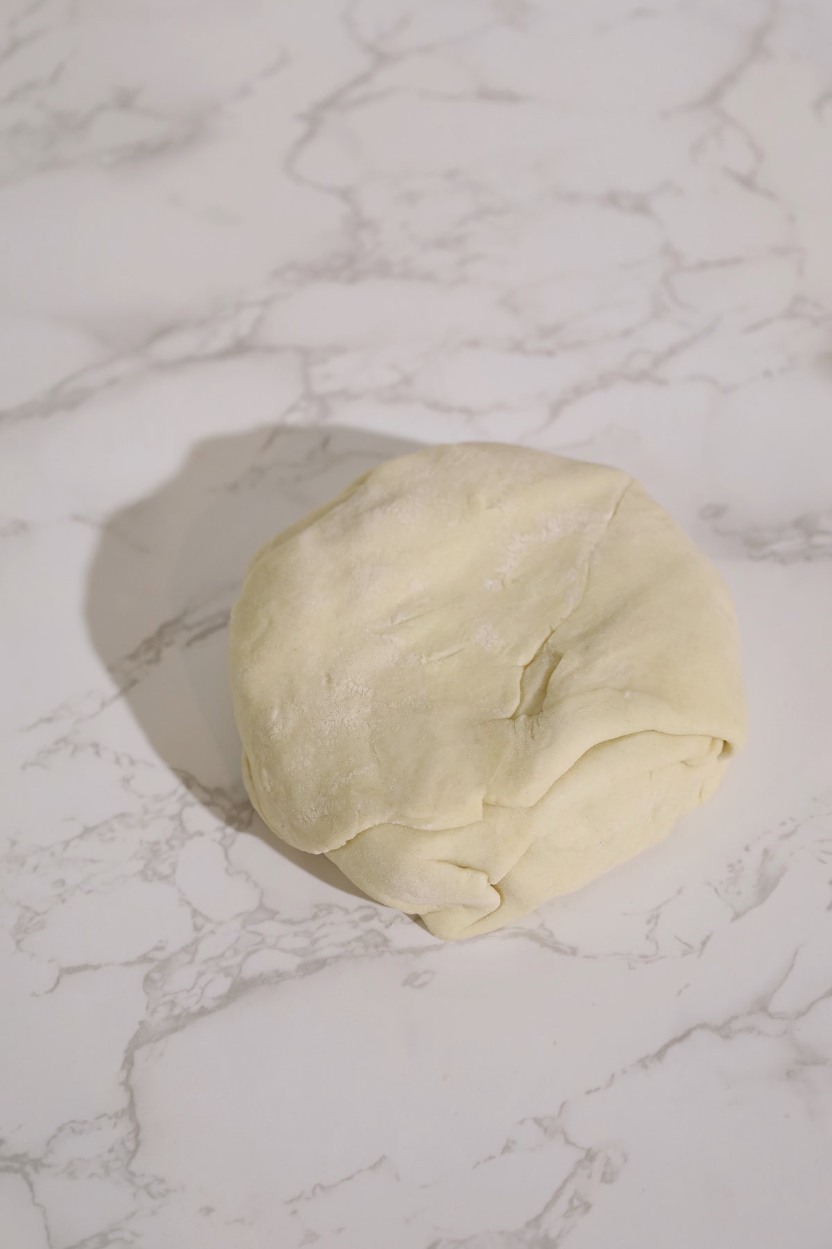 Puff pastry is folded and sealed around a brie wheel to enclose the cheese and cranberry filling.