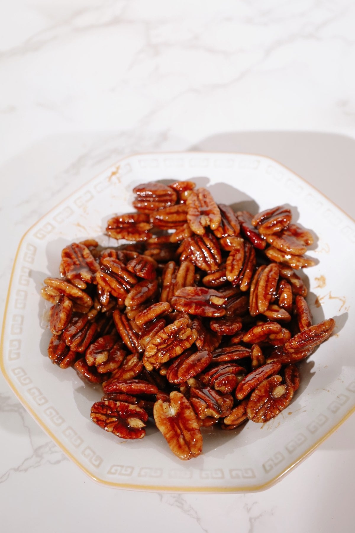 Candied pecans recipe in a white bowl.