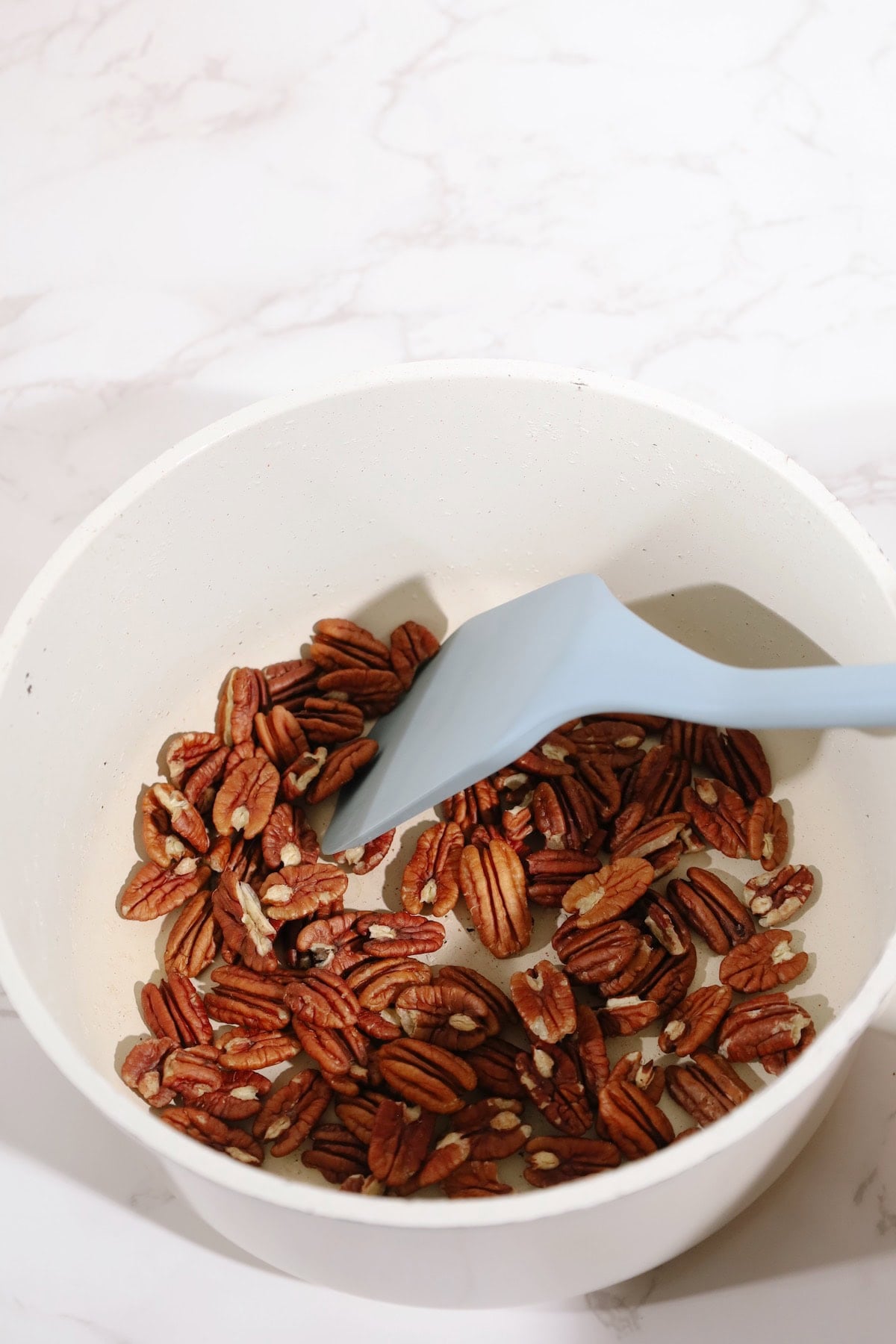 Step one: warm pecans in a skillet.