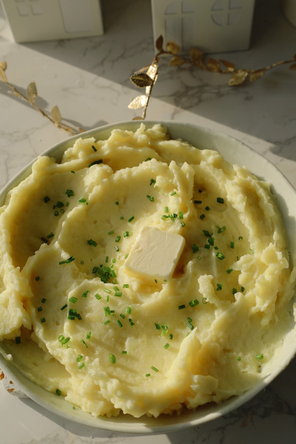 Easy garlic mashed potato recipe in a large bowl with butter.