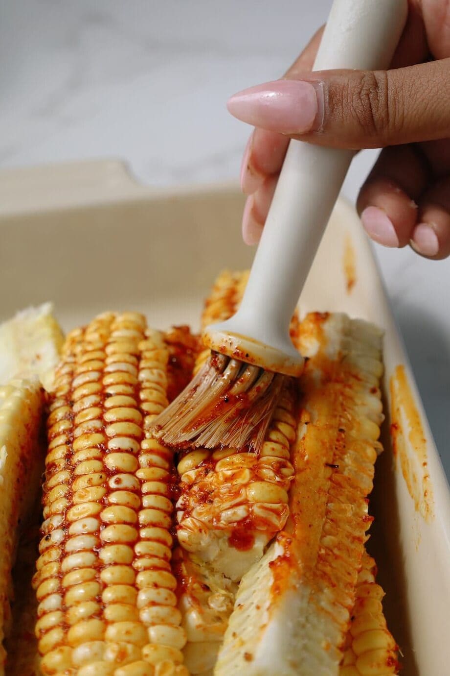 Step three: coat the corn in the cajun butter.