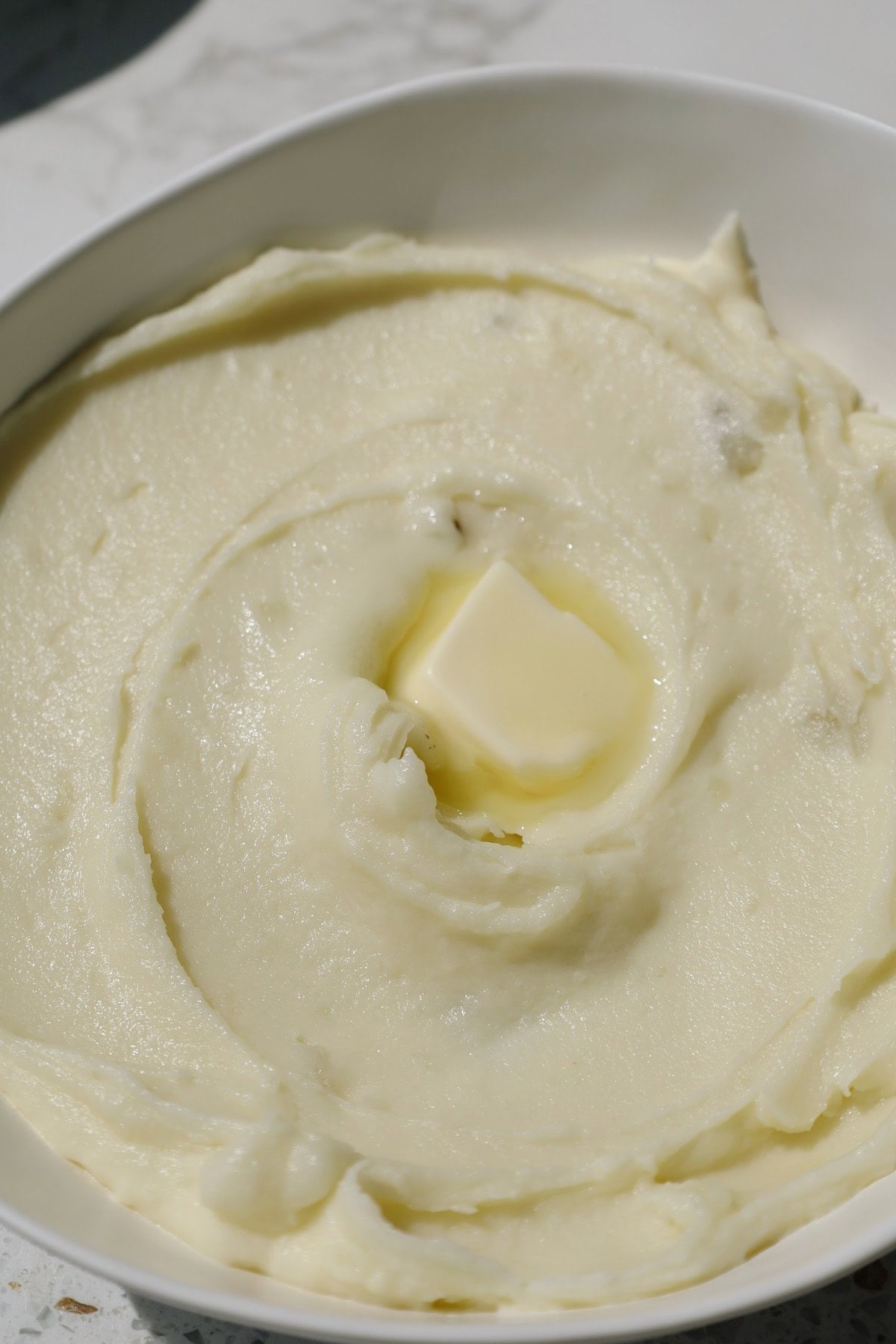 Creamy mashed potatoes with butter on top.