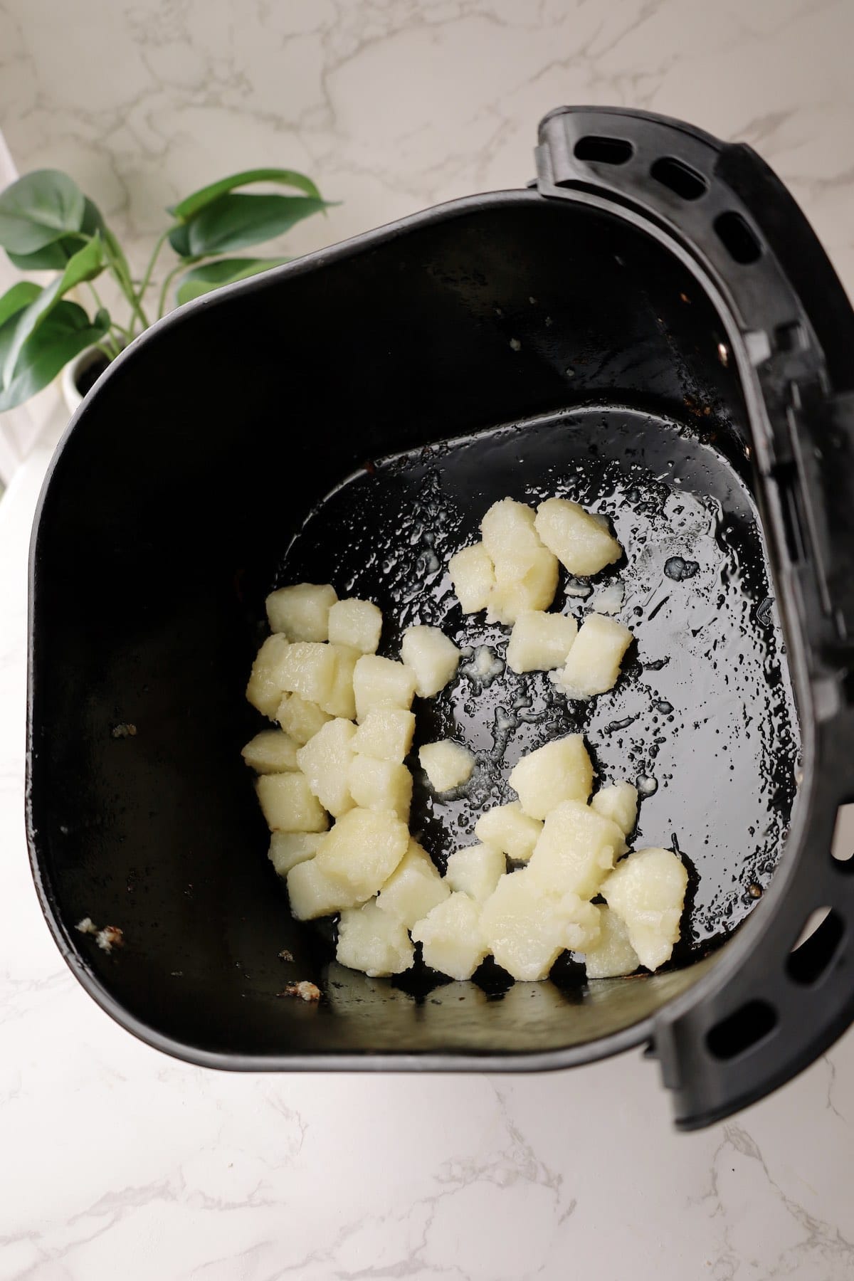 Step Four: pour oil on top of the potatoes inside the air fryer.