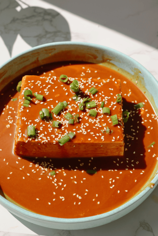 Cold tofu recipe on a plate with sauce on top.