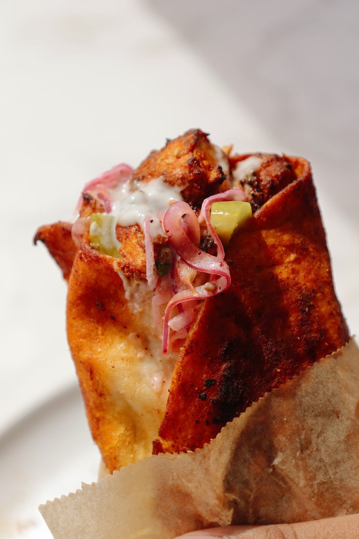 Vegan shawarma wrapped in parchment paper.