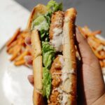 Vegetarian Caesar salad sandwich held in a hand.