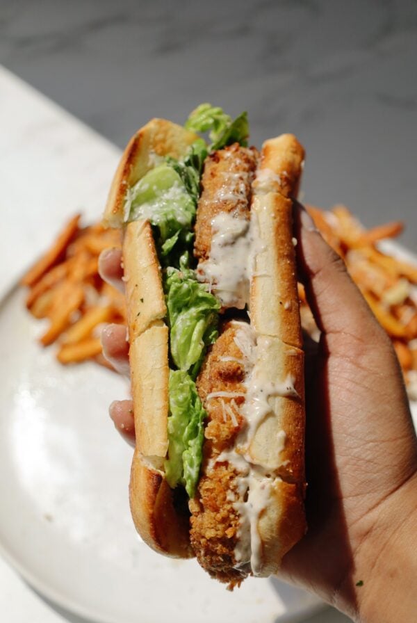Vegetarian Caesar salad sandwich held in a hand.
