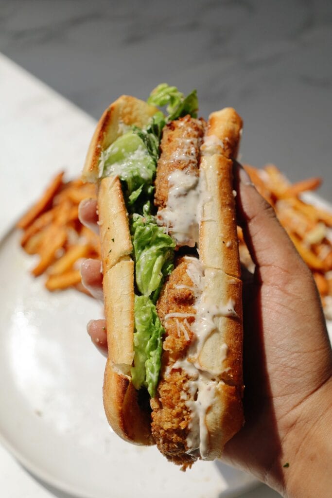 Vegetarian Caesar salad sandwich held in a hand.