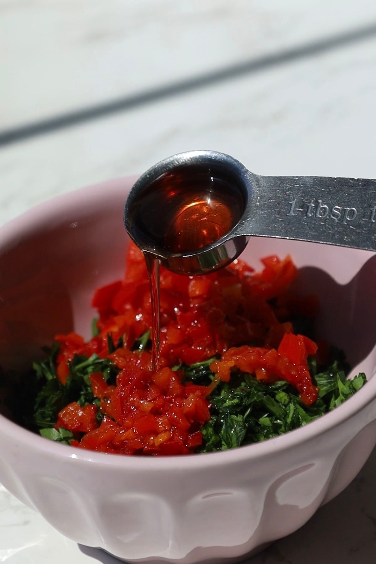 Red wine vinegar poured into the chimichurri sauce.