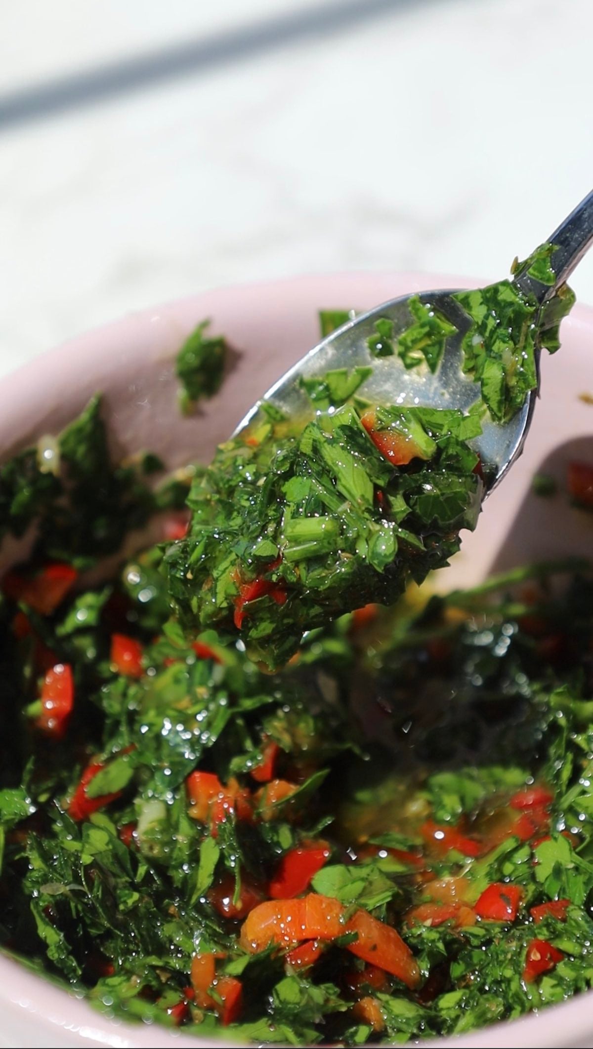 Chimichurri sauce recipe in a bowl with a spoon.
