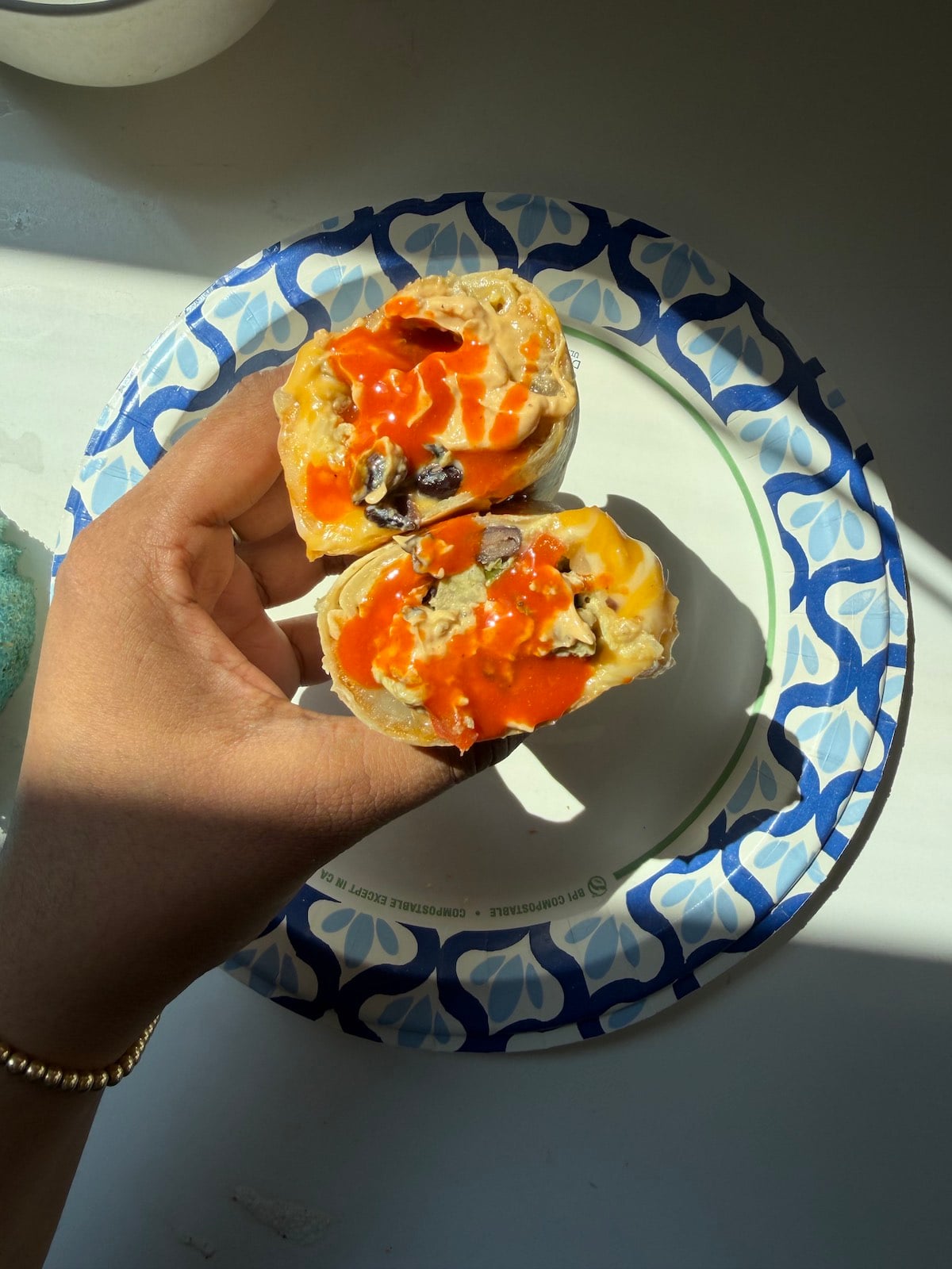 A hand holding the breakfast burrito.