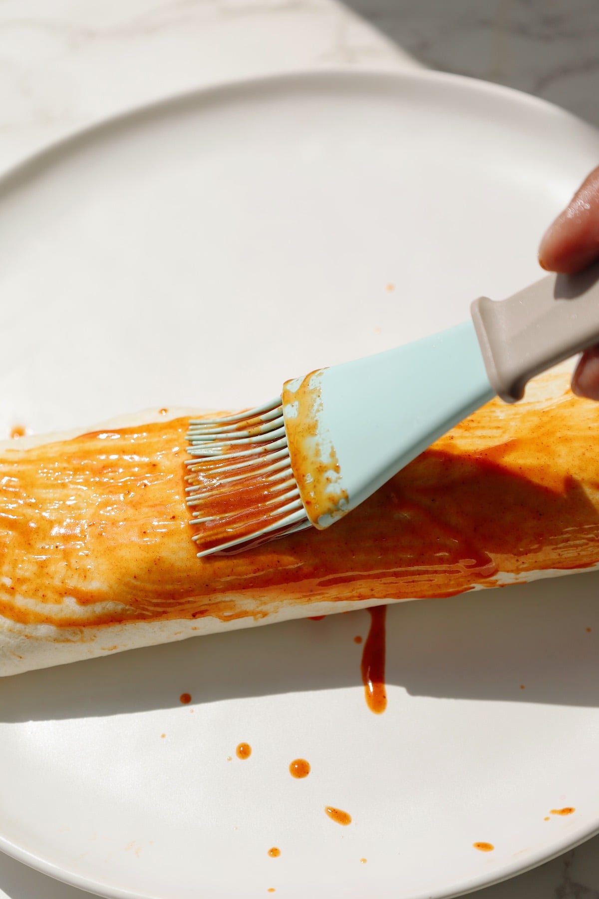 Vegan shawarma step six: brush with red sauce.