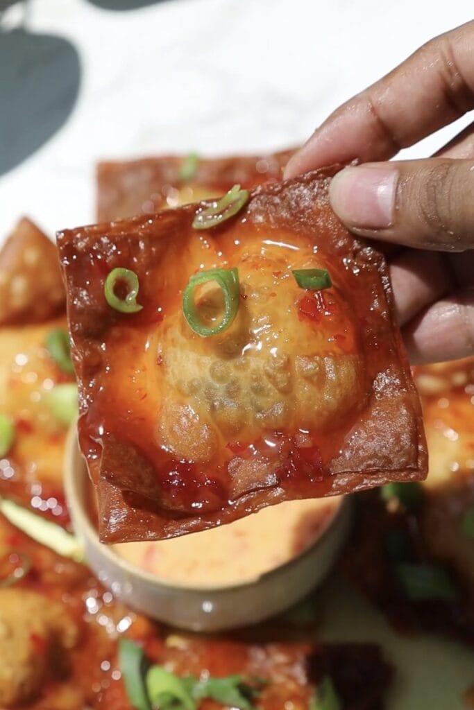 Crab rangoon nachos with sweet chili sauce on top.