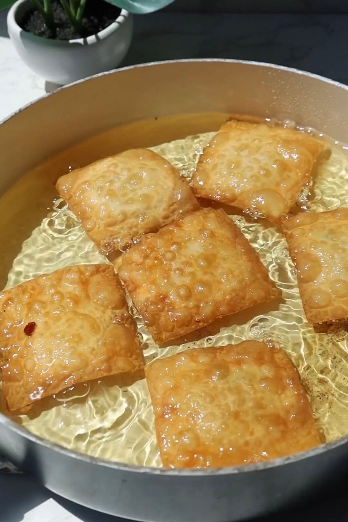 Crab rangoon nachos being fried in oil.