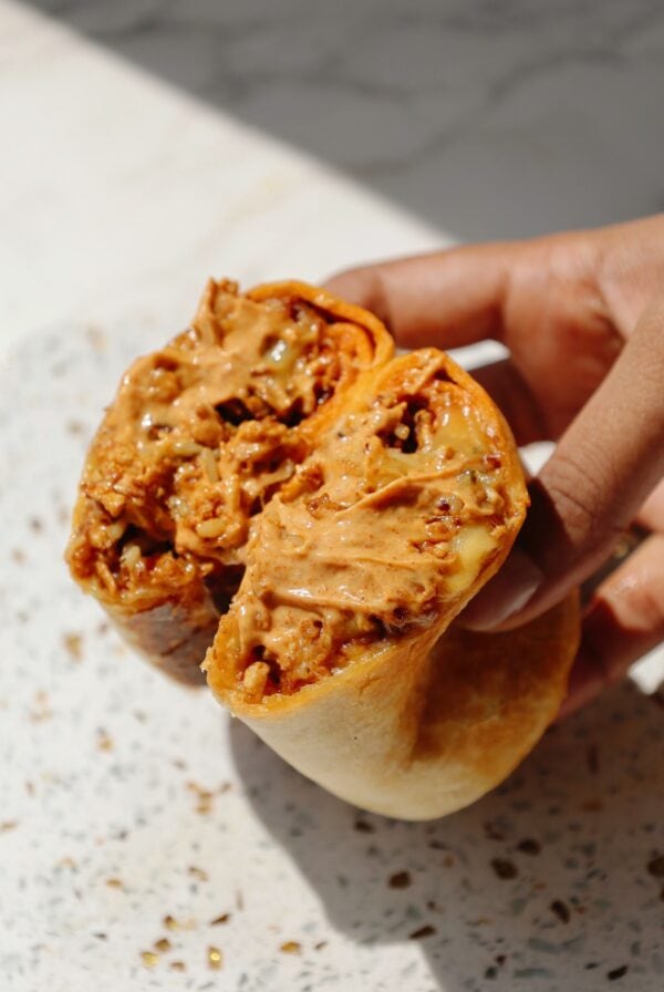 Hand holding the tofu burrito.