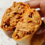 Tofu burrito with chipotle mayo on top.