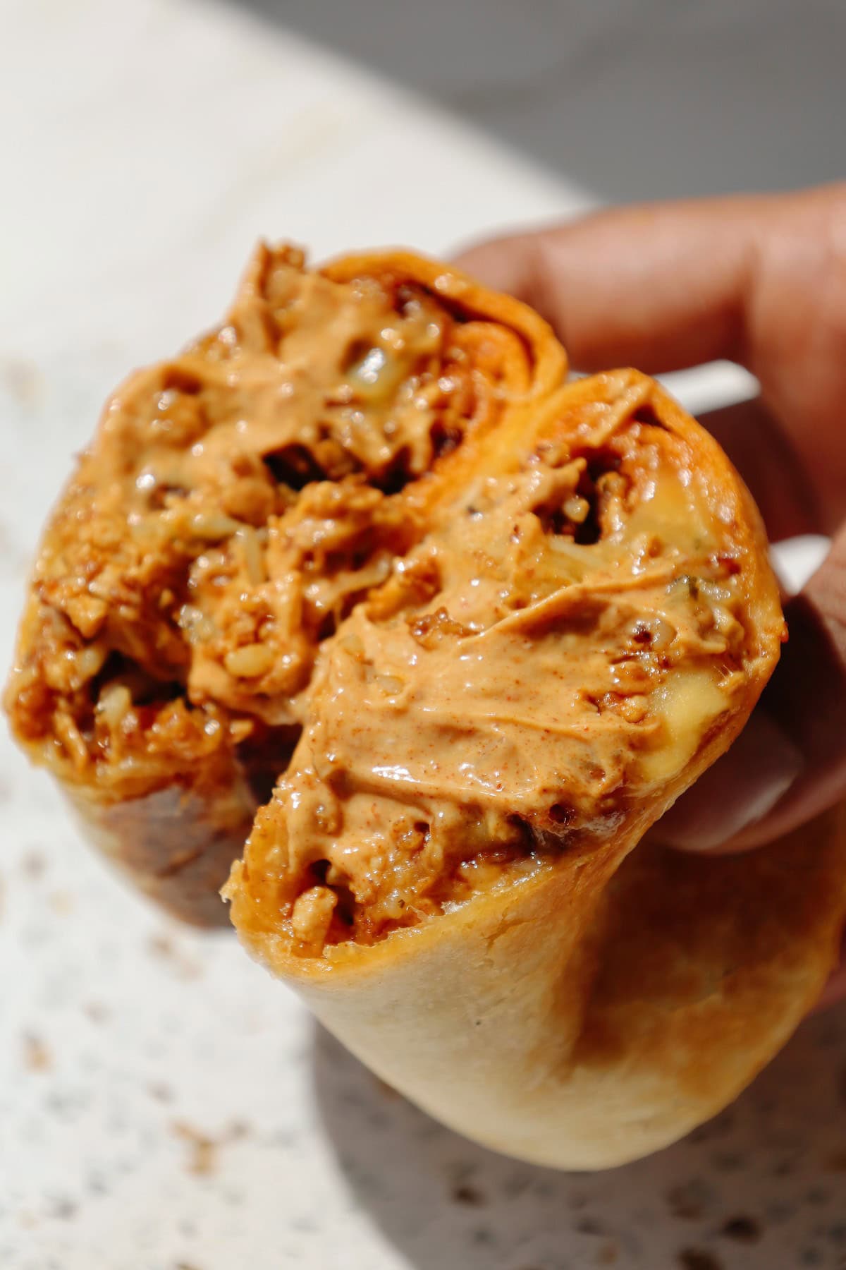 Tofu burrito with chipotle mayo on top.