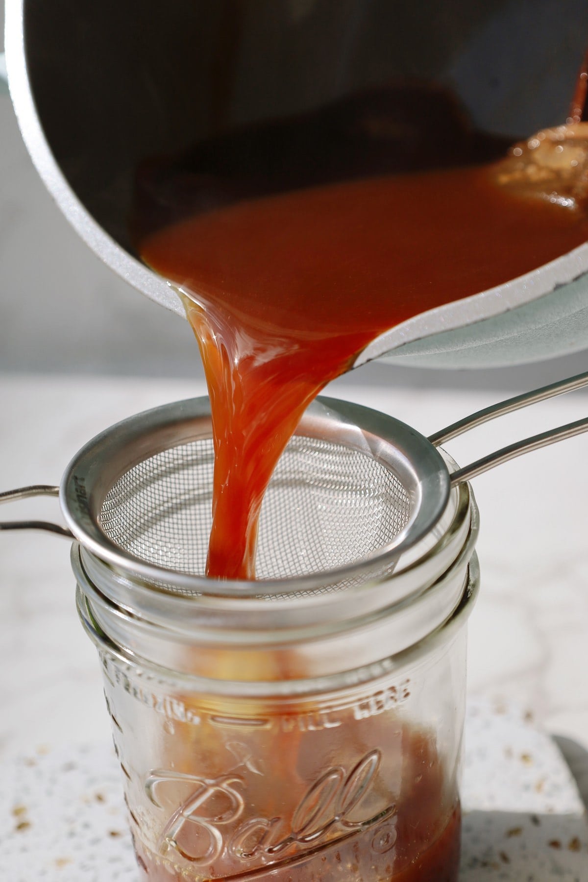 Chai concentrate being poured into a mason jar.