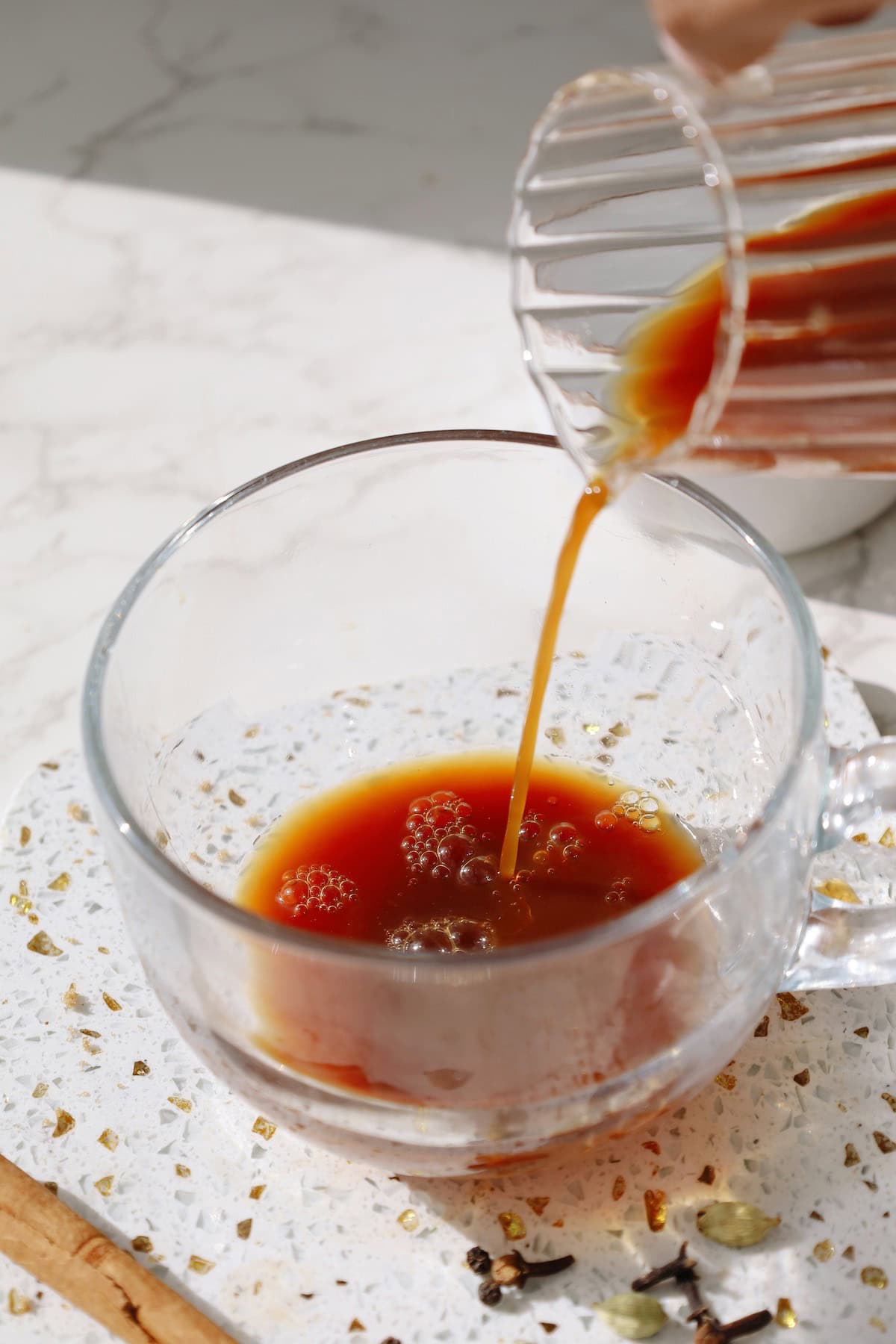 Pouring chai concentrate into a mug for a hot latte.