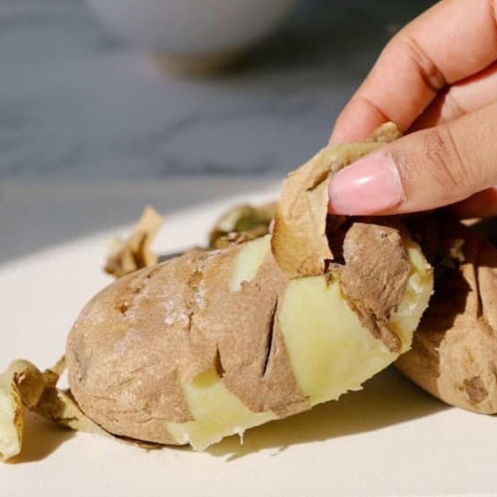 microwaved, cooked potatoes being peeled.
