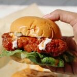 Oyster mushroom burger held in someone's hand.