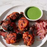 Homemade tandoori chicken drumsticks served with green mint chutney and spicy onions.